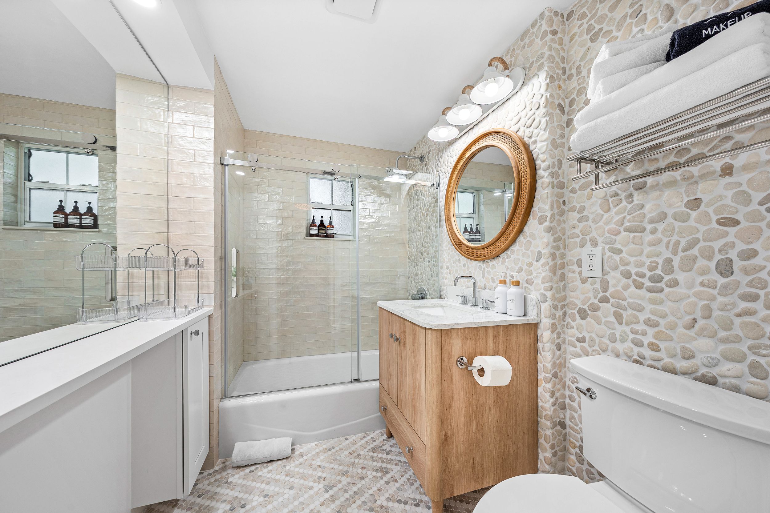 Full Bathroom renovation at Sea Salt & Light Villa featuring stone accent wall and modern vanity